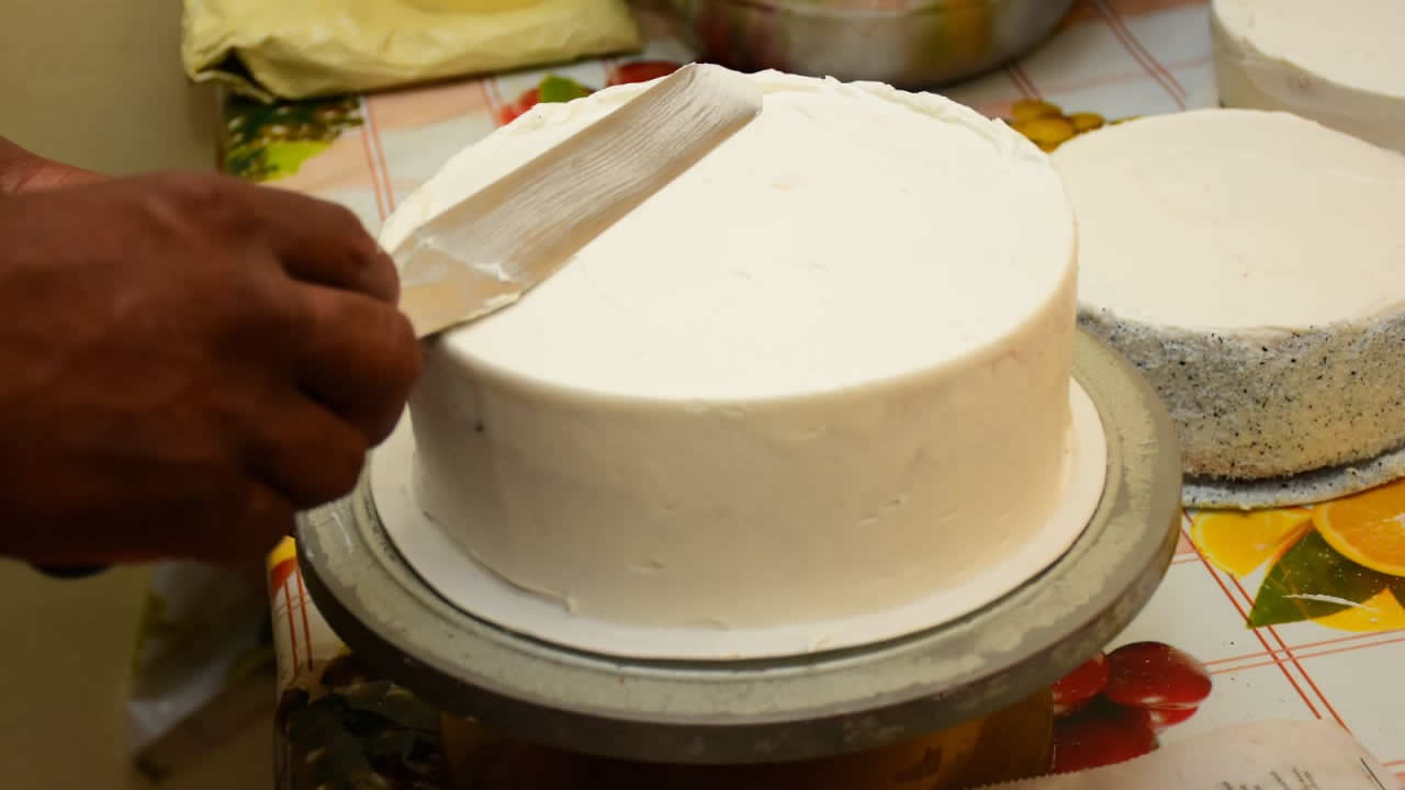 La dernière touche pour l’enveloppe blanche du gâteau qui a pris du lustre en attendant les percées de bleu.