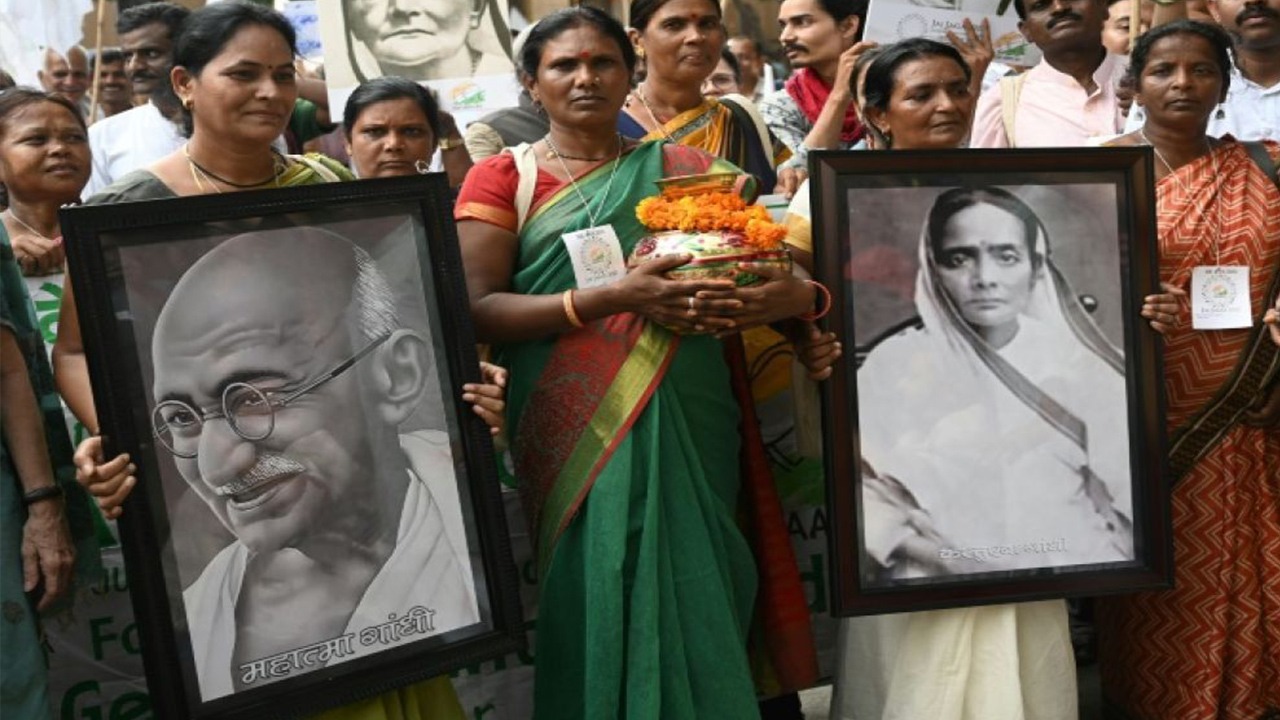 Des militants brandissent des portraits de Gandhi et de sa femme Kasturba, le 2 octobre 2019 à New Delhi, au départ d'une marche de la paix organisée pour le 150e anniversaire de sa naissance